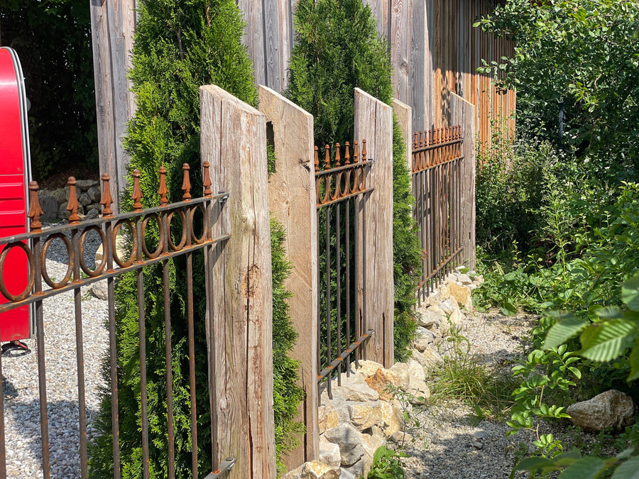 Zaun Belluno an Holzpfosten in begrüntem Steingarten montiert | Unbeschichtet